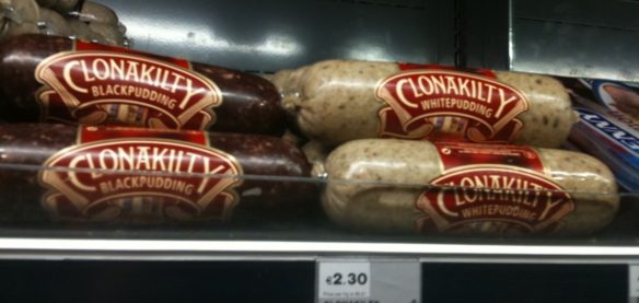 Clonakilty black and white Irish pudding on grocery store shelf.