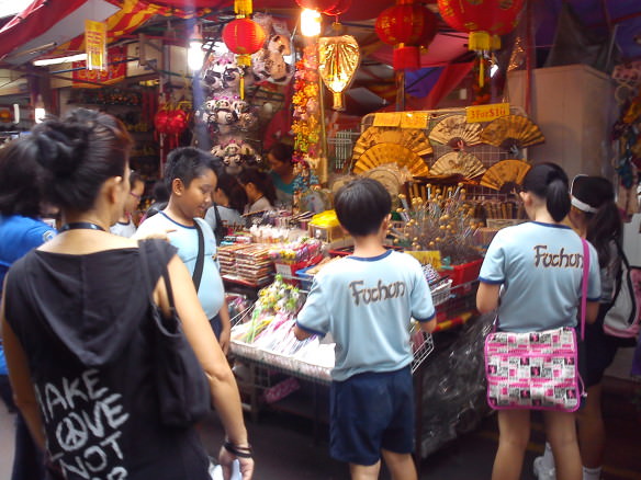 Kids in the Chinatown district of Singapore looking at a stall