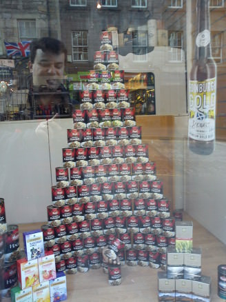 A pyramid of canned haggis in a Royal Mile shop, with the ghost of Haggis lover's past lurking. Haggis and whisky feast!