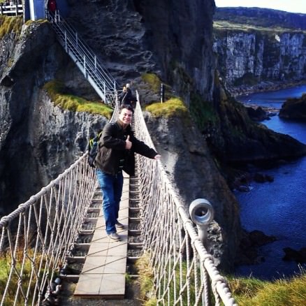 Alex walking in the middle of the Carrick-a-Rede rope bridge in Northern Ireland