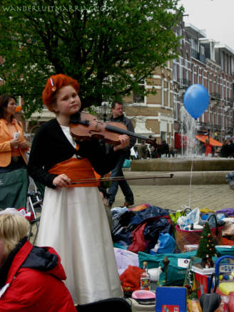 Girl playing violin o the street for Queensday