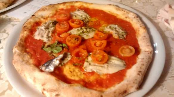 A cheeseless pizza with fresh anchovy fillets