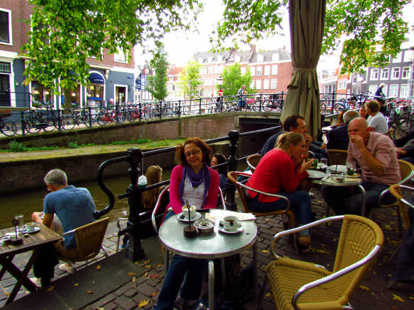 Bell sitting having coffee beside a canal in Amsterdam