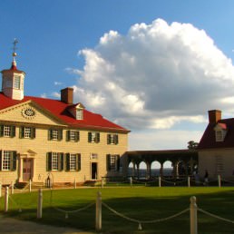 The large main house at Mount Vernon with a partly cloudy blue sky overhead.