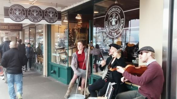 Musicians perform out the front of the original Starbucks in Seattle.