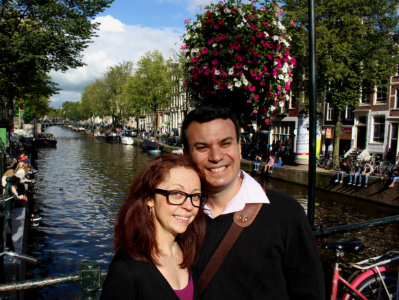 Alex and Bell Kallimanis in Amsterdam, Netherlands under flowers and next to a canal in the historic center.