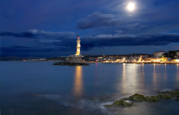 Lighthouse with the moon shinning down and the sea