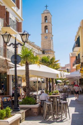 people sitting at cafe terraces in the old town of Chania