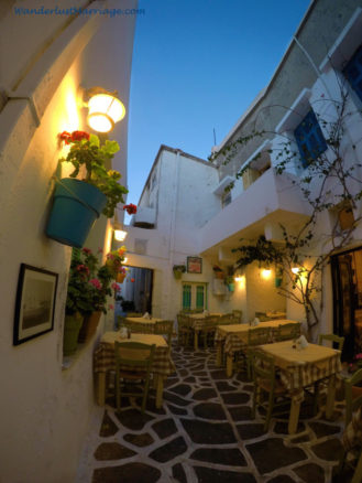 Narrow ally of Naxos at dusk with tables and seats out ready for dinner