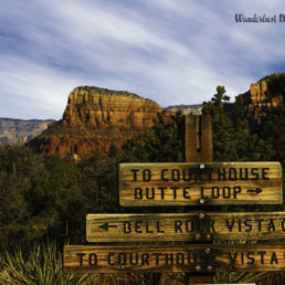 A sign in Sedona, Arizona with a beautiful red mountain in the background.
