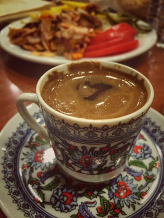 A cup of turkish coffee in Istanbul with food in the background