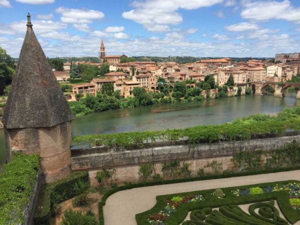 River running through Albi withe blue skies and fluffy clouds