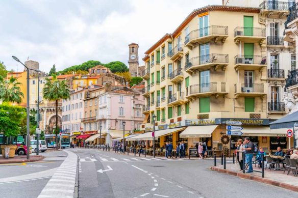 Street in Cannes with people walking and sitting at cafes