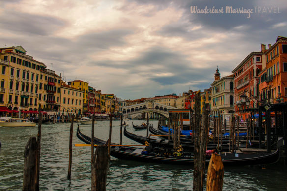 Canals with the gondolas parked and a dark moody sky over Venice