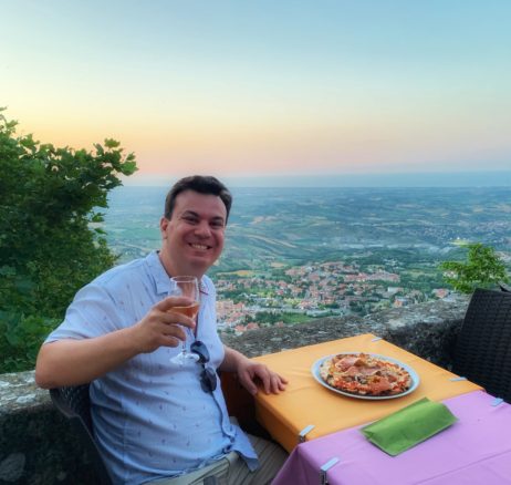 Alex with pizza and wine overlooking the romantic  San Marino at dusk