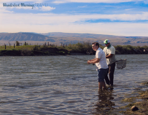 Alex fly fishing with rolling hills in the background