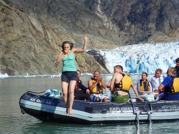 Bell jumping out of a small skiff boat into the water in front of South Sawyer Glacier