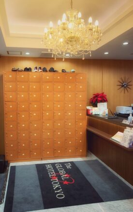 Entrance to hotel with a chandelier and shoe locker