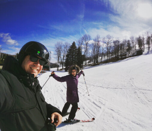 Alex and Bell skiing under blue skies at Seven Springs Mountain Resort in the Laurel Highlands 