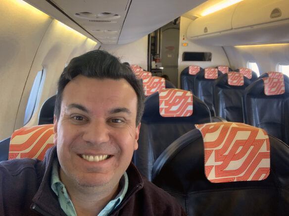 Alex with the seats on the plane behind him empty