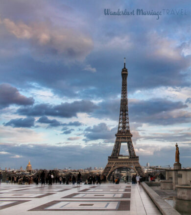 The Eiffel tower in the distance with people walking around