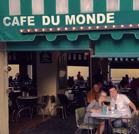 Alex and Bell sitting under the Cafe Du Monde awning