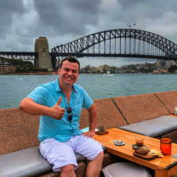Alex giving a thumbs up to the Sydney harbor bridge