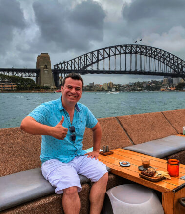 Alex giving a thumbs up to the Sydney harbor bridge