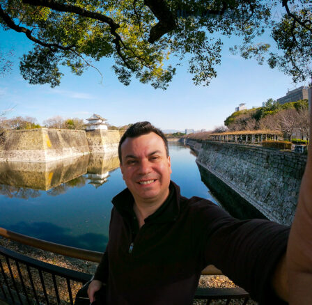 selfie of Alex outside exterior walls of Osaka Castle, overlooking the moat