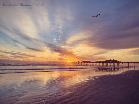 Sunrise over the ocean with a pier in the background