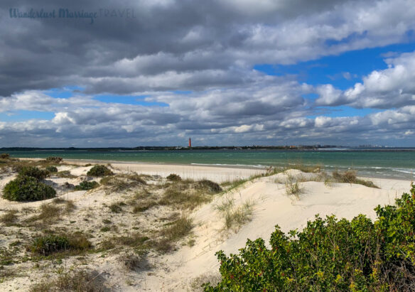 View of the dunes at Smyrna Dunes State Park with the lighthouse in the distance across the inlet