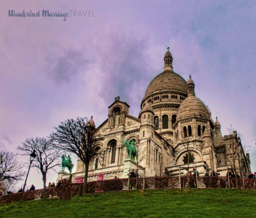 White church (Sacre Coeur), atop a green hill and dusk sky in Paris