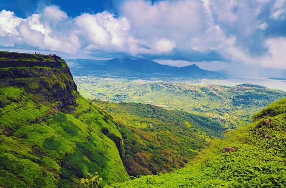 Lush green mountain range, with a blue sky and white clouds