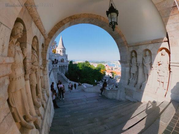 Statues and people milling around on Fisherman's Bastion on Castle Hill in Budapest, Hungary.