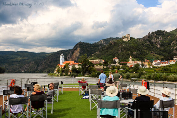 Passengers on the deck of Emerald Cruises' Emerald Destiny ship watching as we sail into Durnstein, Austria along the Danube River.