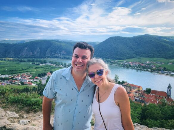 Photo of Alex and Bell up high and the village of Durnstein is below with the river Danube and then mountains in the background