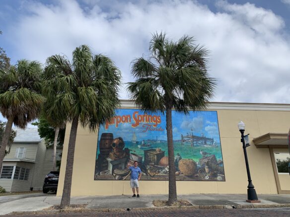 Alex standing in front a lovely Tarpon Springs, Florida mural