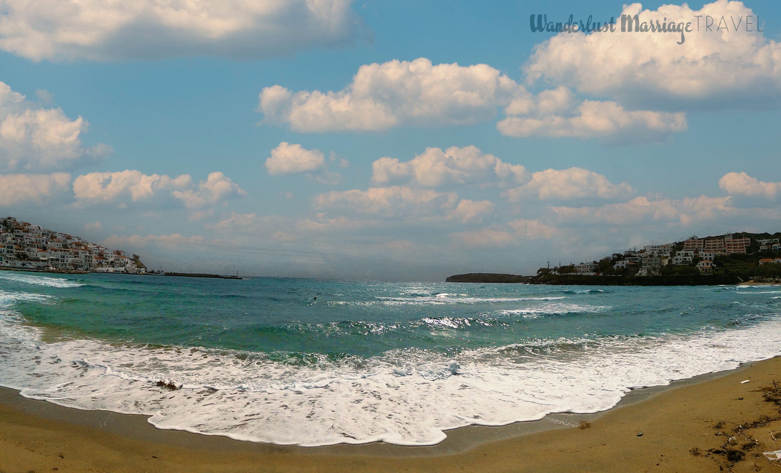 The waves lapping up on the beach nestled in the bay, with the white washed houses of Batsi off to the left