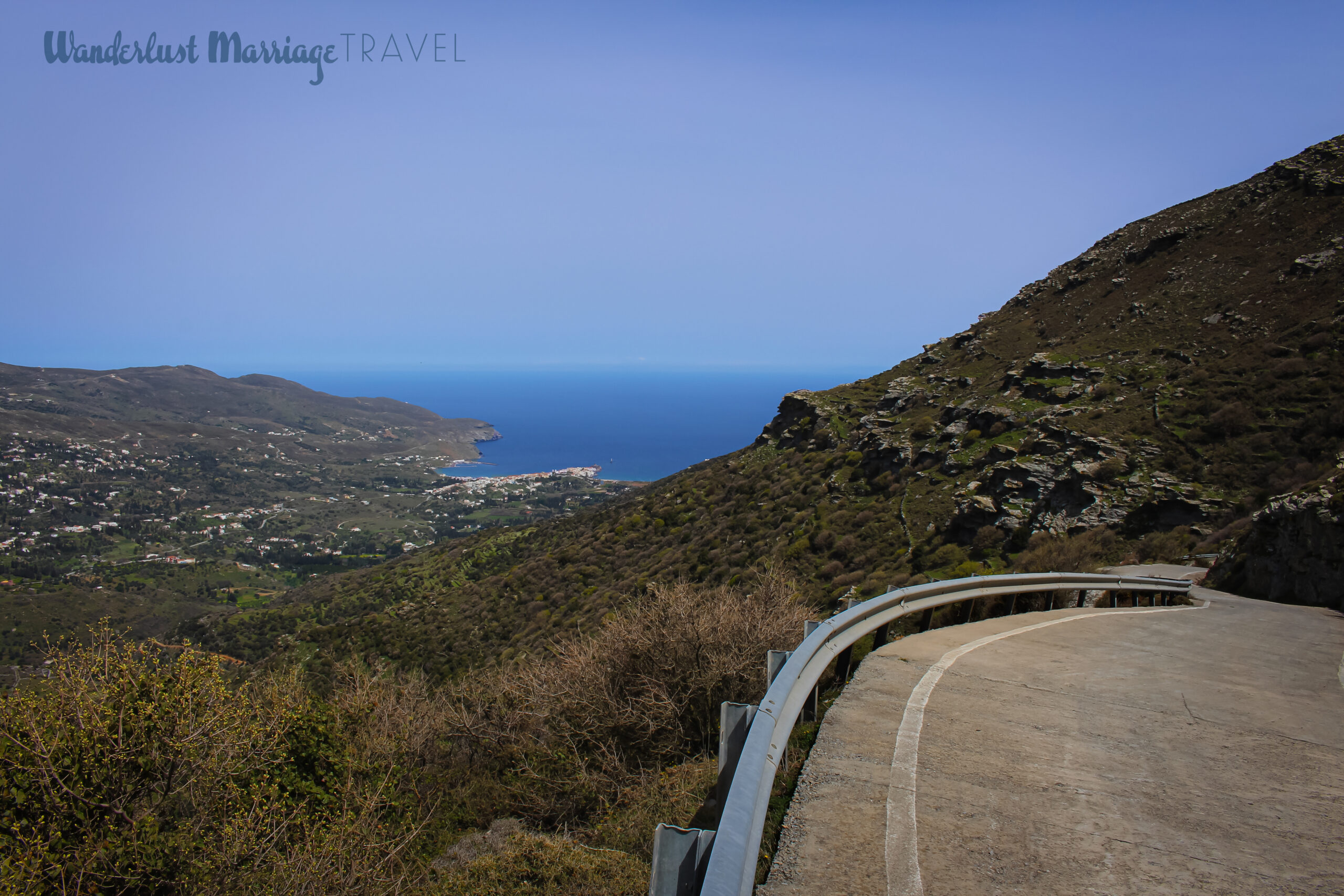 View of the seaside village from a top a mountain with the winding road and blue skies