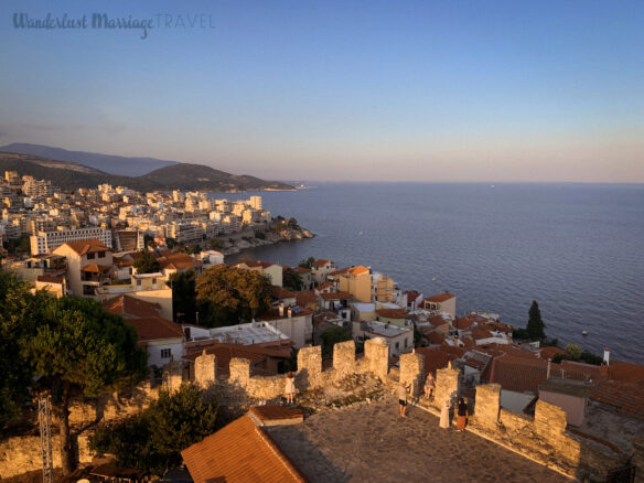 View overlooking white houses with terracotta roofs and the sea with mountains off to the side