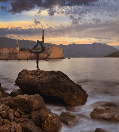 A bronze girl gracefully holds one foot in her hand behind her head as the sea laps as the rocks, and the sunsets over the oldtown of Budva