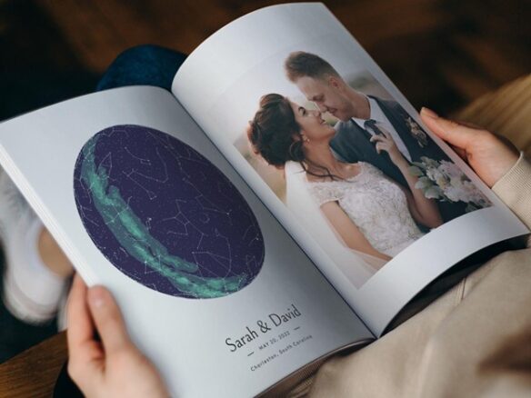 A person is sitting with the wedding photo book in their lap with pictures of the bride and group and maps