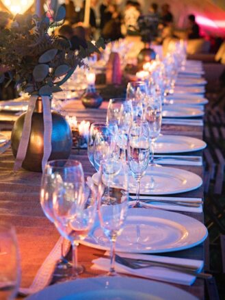 A long table set with china and nice glassware.