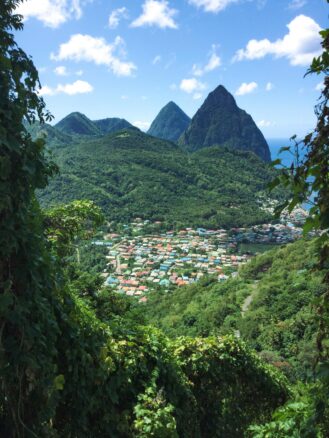 steep lush green mountains rise above the town of Soufrière, Saint Lucia.