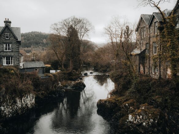 A stream cuts through town in Betws-y-Coed, with a grey sky