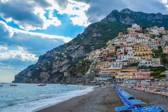 View of Positano's colorful buildings rising along the mountain from Marina Grande Beach.