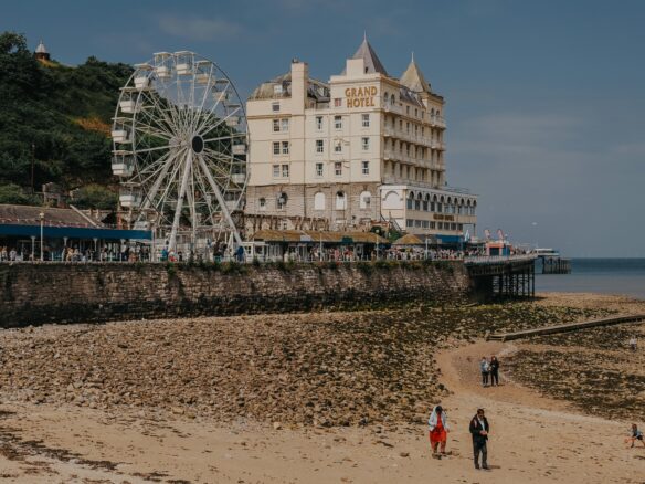 Llandudno beach with the Grand Hotel and a ferris wheel located along the promenade.