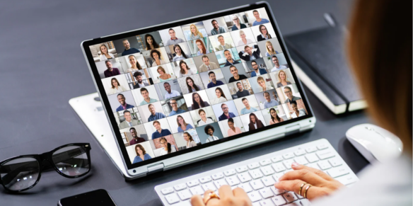 Someone typing on a laptop filled with faces on the screen.
