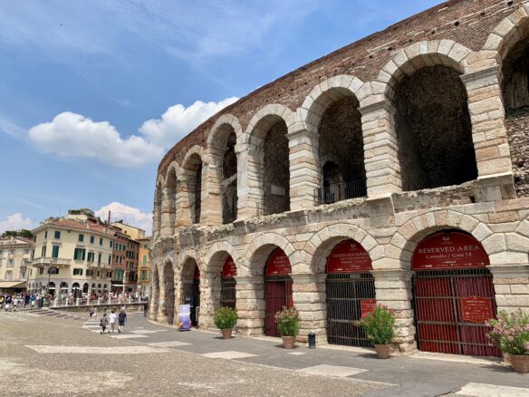 Arena di Verona (Verona Arena) with a blue sky overhead.