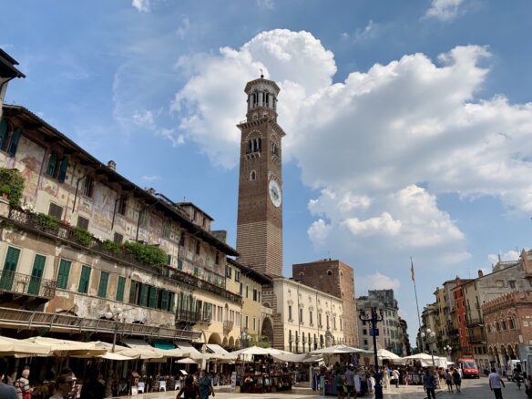 Verona, Italy bustles with people on a summer day with partly cloudy skies.